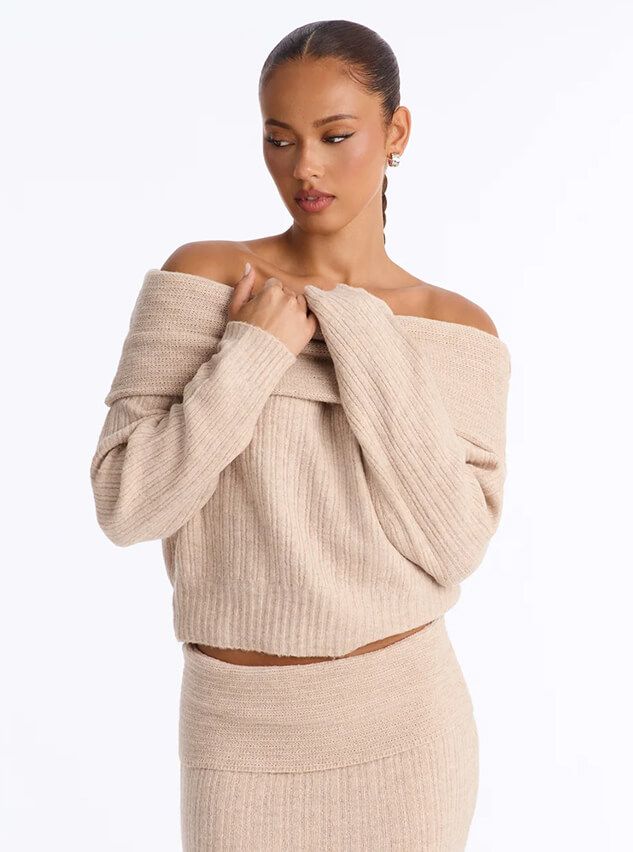 Woman wearing a cozy beige off-the-shoulder knit sweater and matching skirt from the new fall fashion collection on a white background.