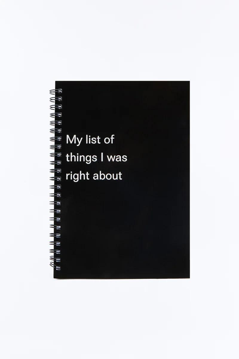 Cuaderno de espiral negro con "My list of things I was right about" impreso en la portada.