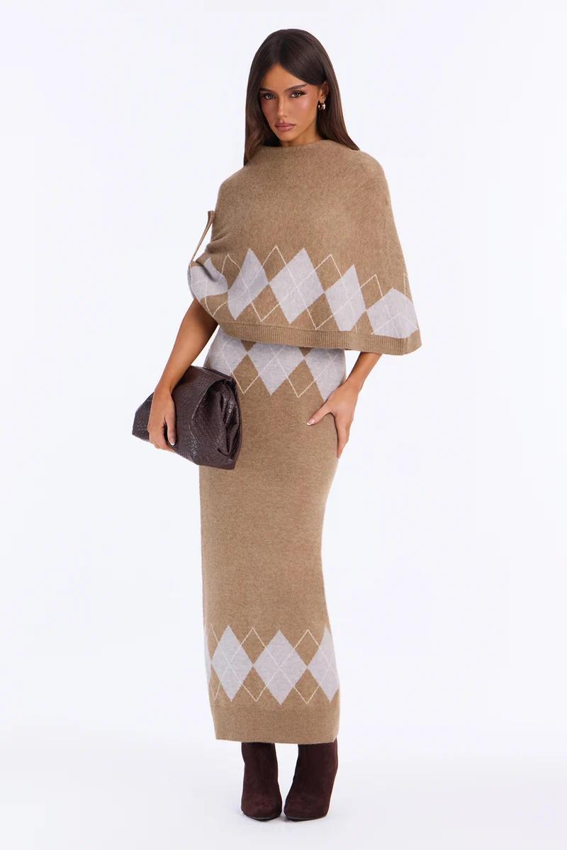 Woman wearing a chic camel argyle knit maxi skirt and capelet set with brown clutch, showcasing stylish fall knitwear collection.