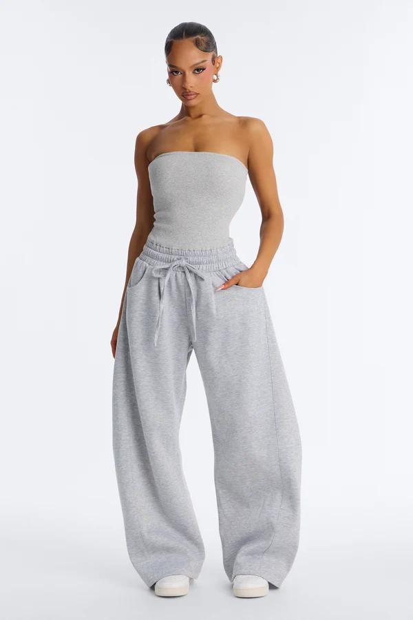 Model wearing a grey strapless tube top and matching wide-leg drawstring sweatpants from a cozy casual athleisure loungewear collection.