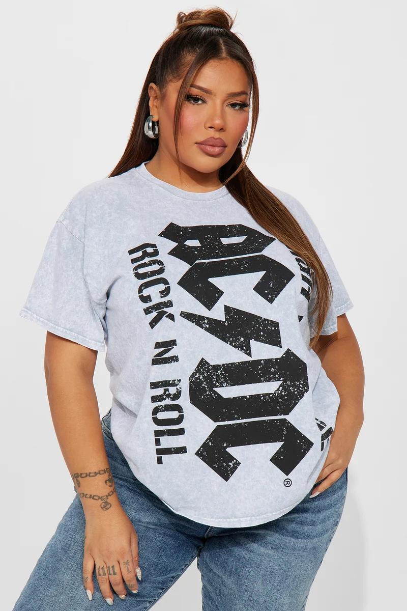 Woman in a gray acid-wash AC/DC graphic tee and black leather mini skirt.