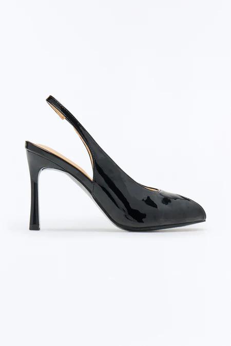Shiny black patent leather slingback high heel with a pointed toe, slender flared heel, and tan insole on a white background.