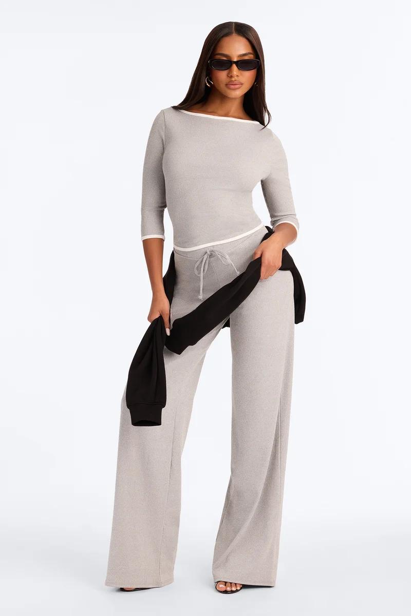 Model wearing a chic light grey knit loungewear set with wide-leg pants and boatneck top, showcasing cozy modern womenswear.