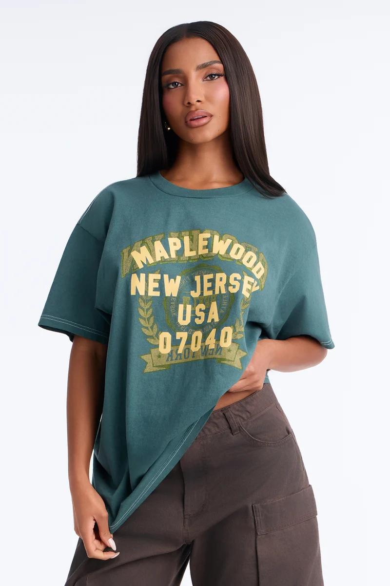 Woman in an oversized teal Maplewood New Jersey vintage graphic t-shirt and brown cargo pants.