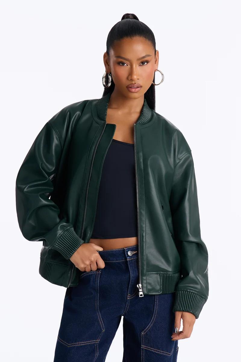 Model wearing an oversized dark green faux leather bomber jacket.