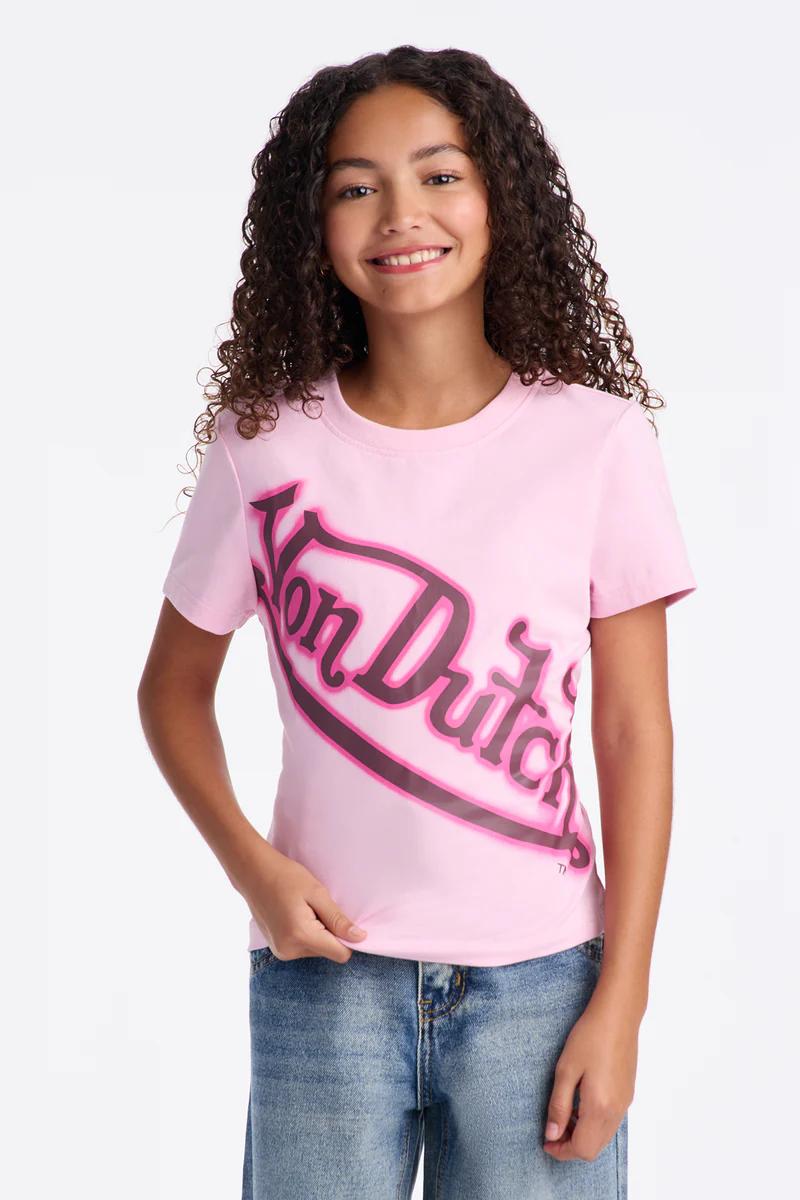 Smiling young girl in pink Von Dutch t-shirt & blue jeans.