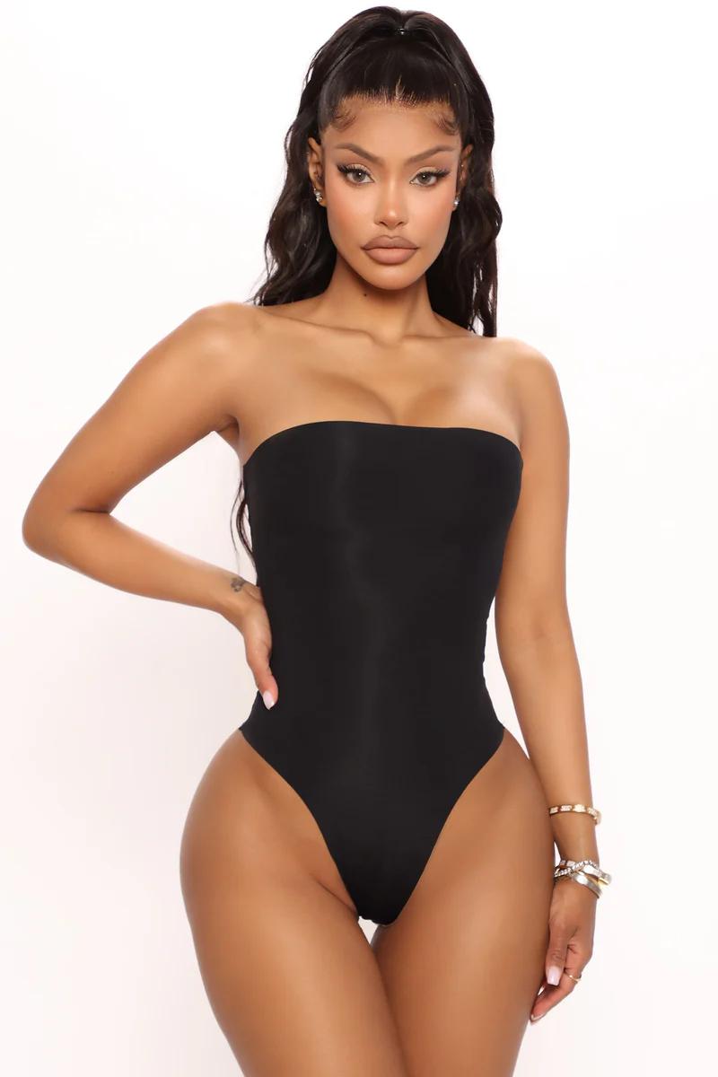 Mujer con bikini blanco de lunares, hombros descubiertos y bragas de corte alto.