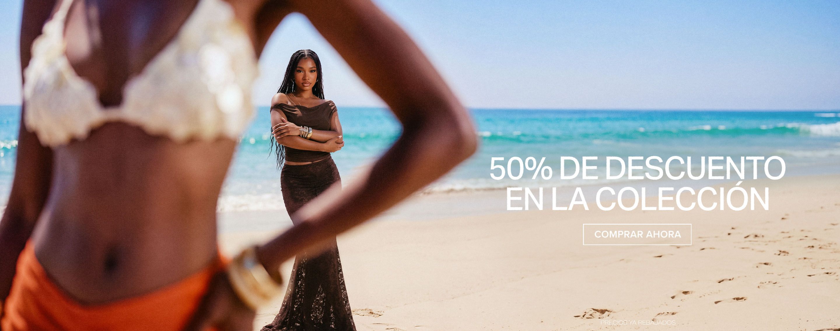 Mujer en vestido de playa marrón oscuro en la arena, brazos cruzados, promocionando 50% de descuento en la colección. ¡Compra ahora!