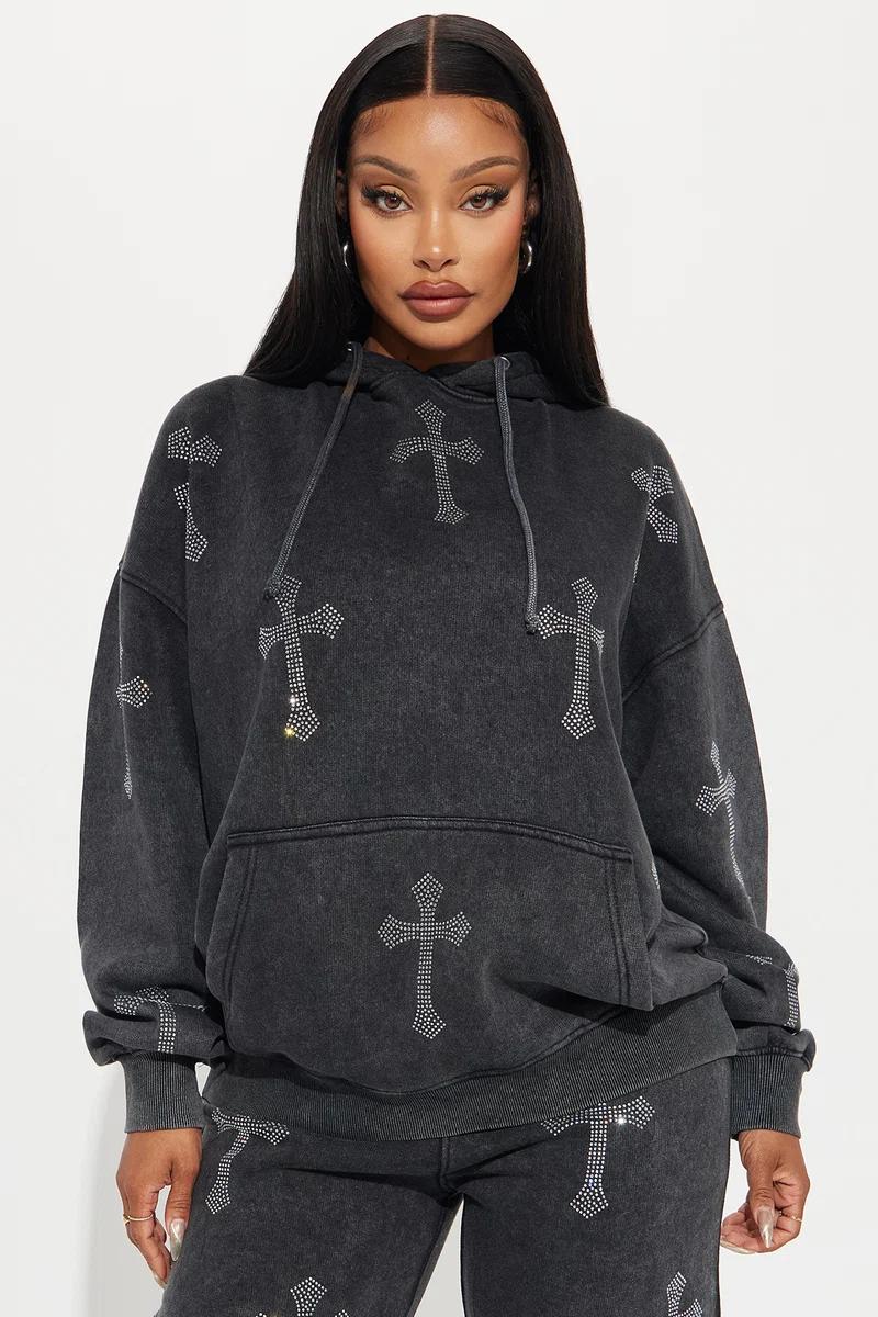 Mujer con sudadera oversize gris lavado al ácido y detalles de cruces de strass.