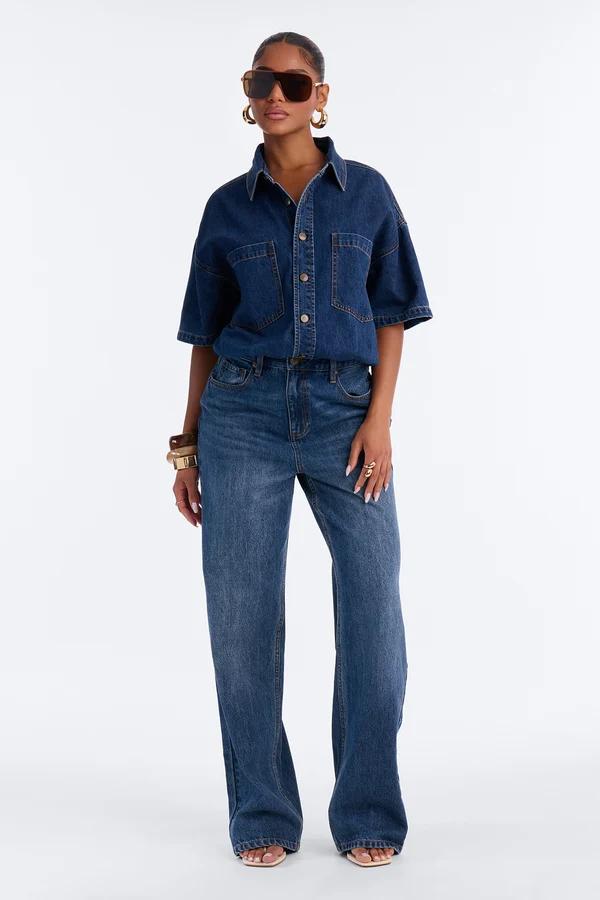Model in a blue double denim outfit with wide-leg jeans and a short-sleeve shirt, showcasing a new trendy casual fashion collection.