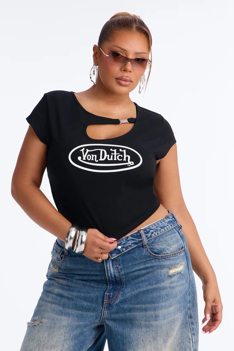 Model wearing a black Von Dutch cutout t-shirt with logo and blue jeans.