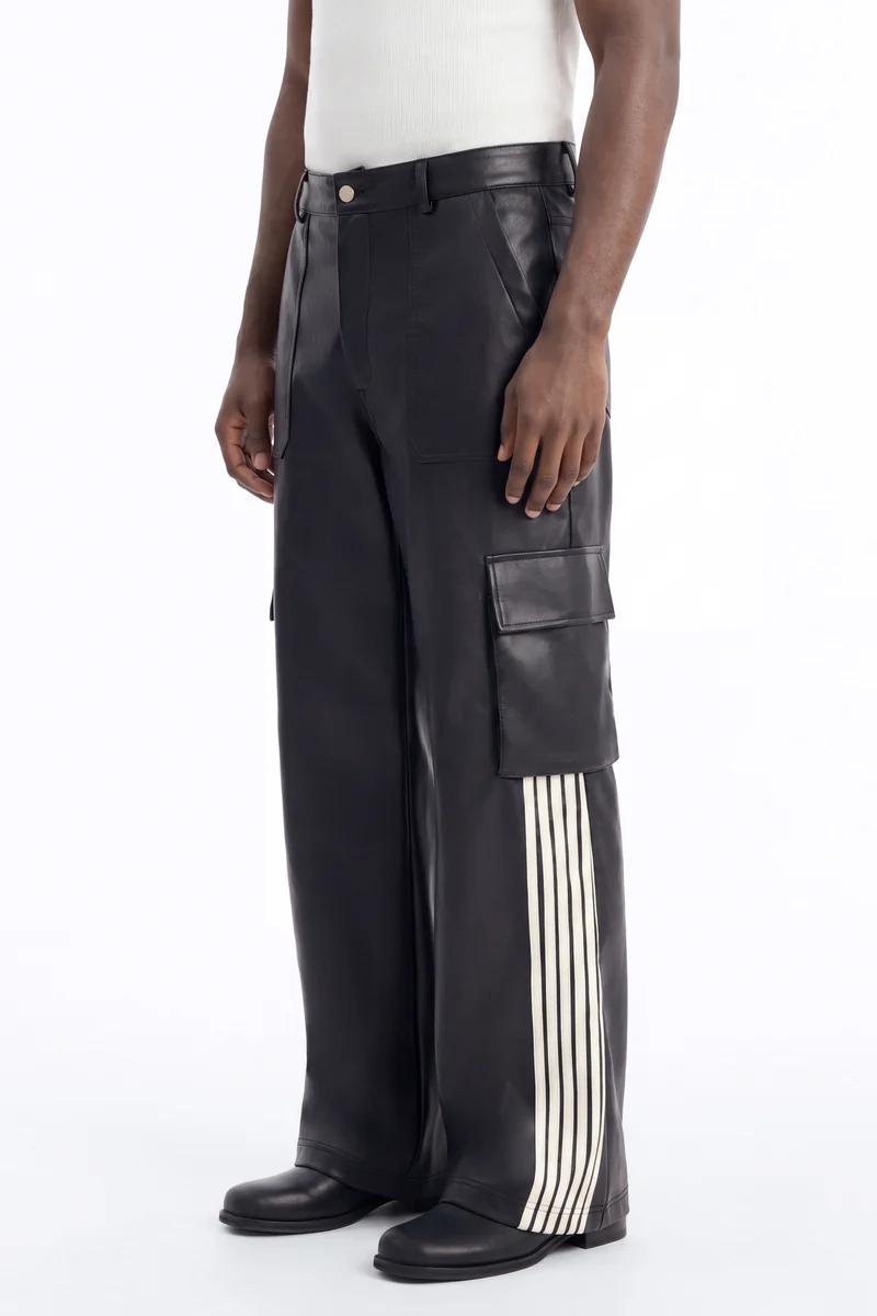 Black leather cargo pants with a side white triple stripe, modeled with a white tank top. Elevate your style.