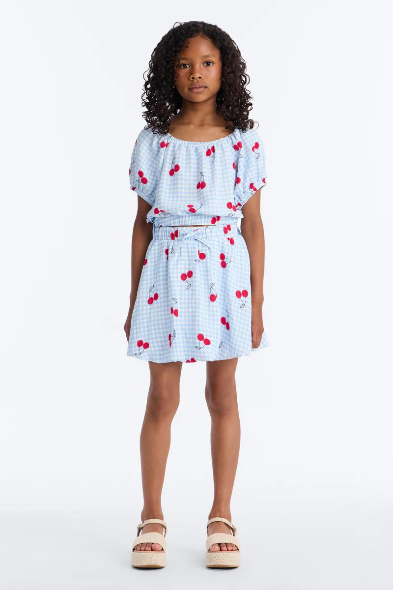Girl in blue gingham cherry crop top & skirt set with espadrille sandals. Kids fashion.