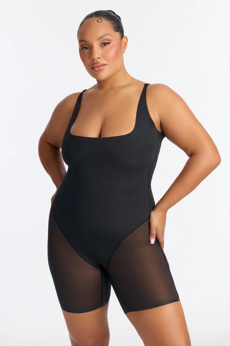 Plus size woman in black square neck mesh panel shapewear bodysuit.