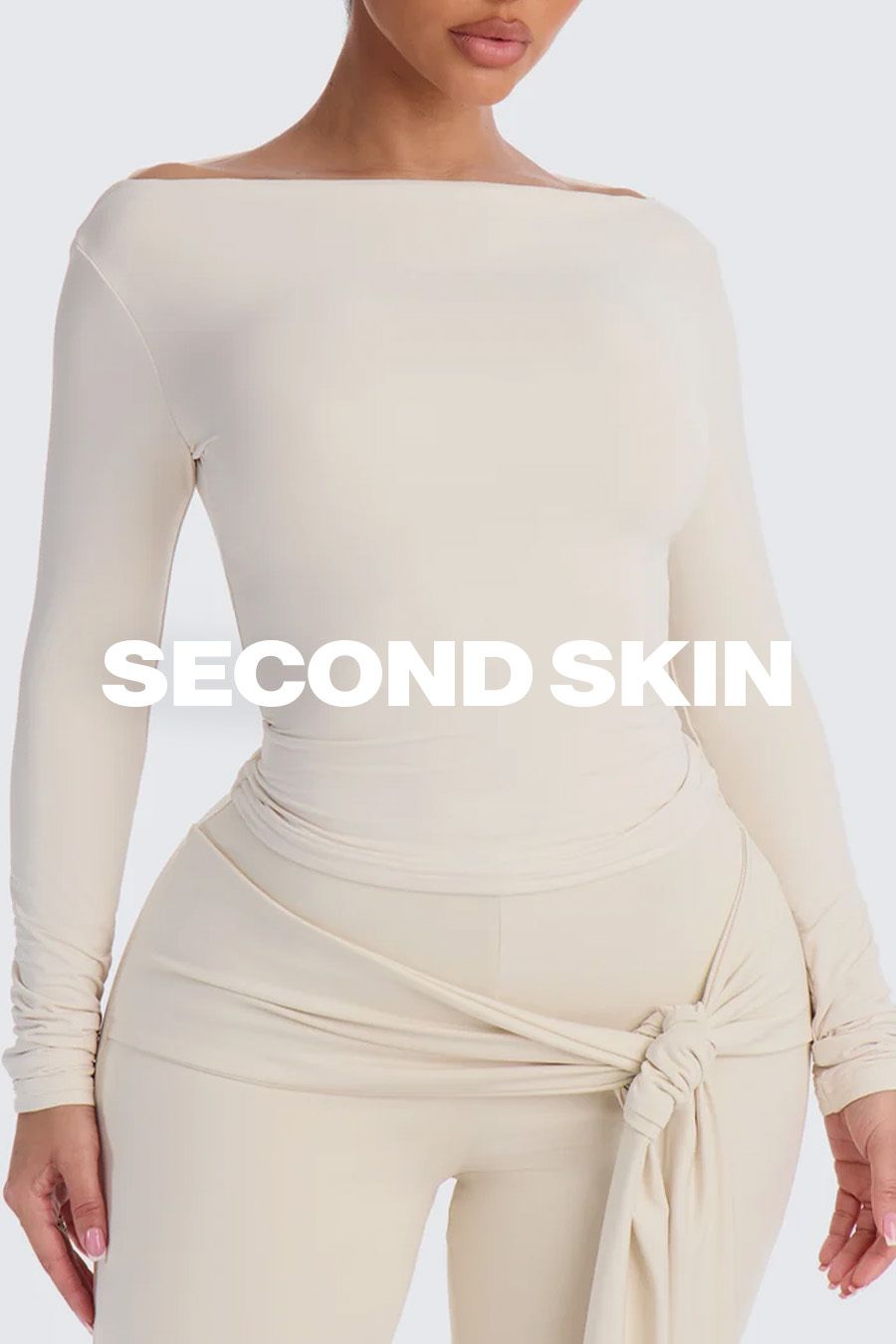 Model wearing a cream boatneck long-sleeve top and matching pants, promoting the form-fitting Second Skin apparel collection.