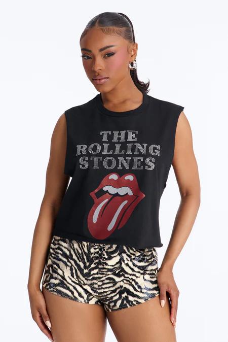 Mujer con top negro Rolling Stones de tirantes, logo tachonado y lengua roja, más shorts con estampado de cebra y cordones.