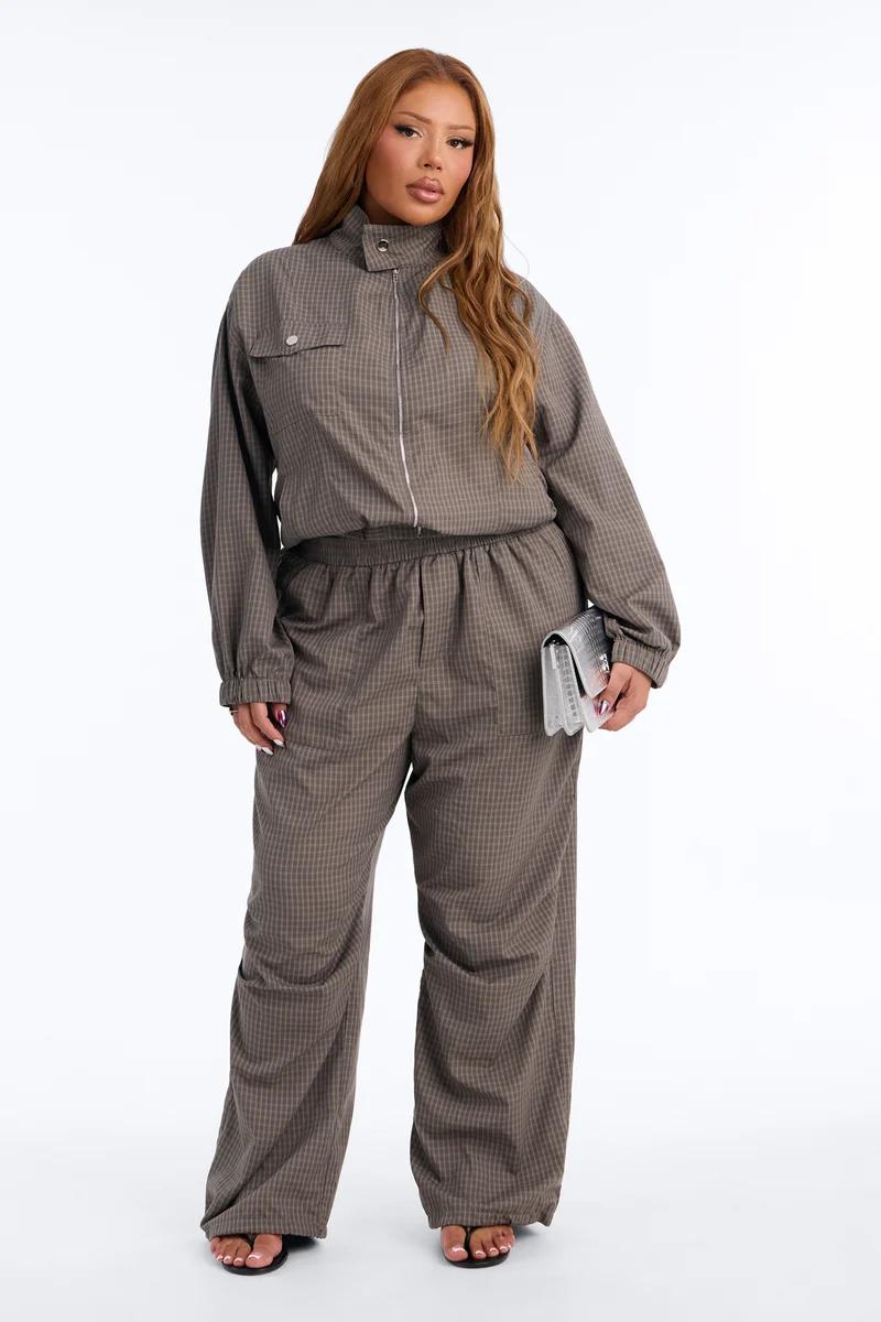 Plus-size model in a brown plaid matching set with a zip-up jacket and wide-leg trousers, showcasing chic women's co-ord streetwear.