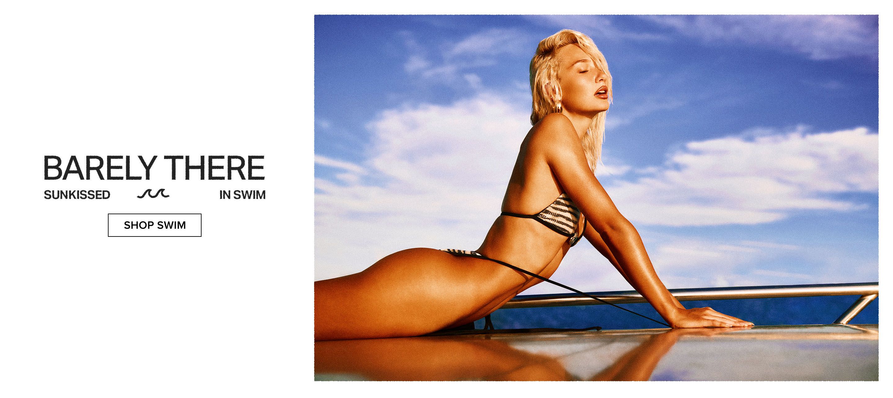 Blonde woman in striped bikini, sunkissed and reclining under a blue sky. Explore our new Barely There swim collection.