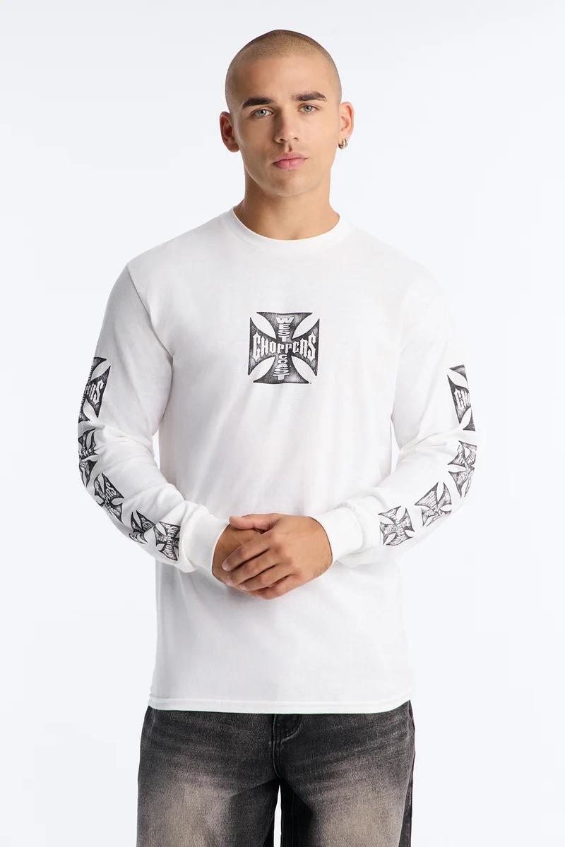 Man models white long-sleeve West Coast Choppers tee with black Iron Cross logos on chest and sleeves.