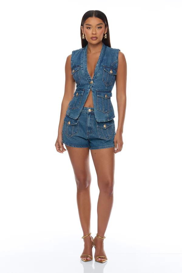 Mujer modela vibrante conjunto de dos piezas estampado de frutas: crop top bustier con tirantes y pantalones anchos. Colección de verano.