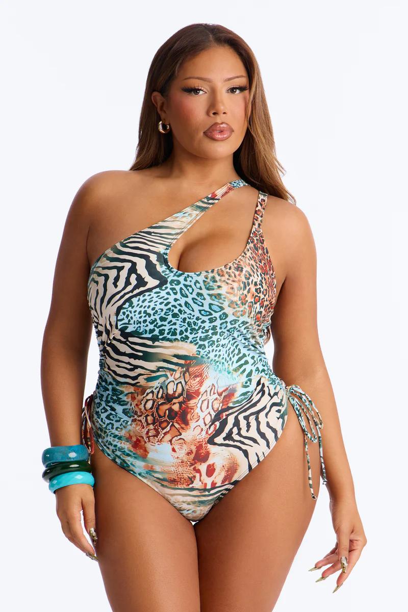 Plus size woman in a trendy one-shoulder animal print swimsuit with drawstrings.