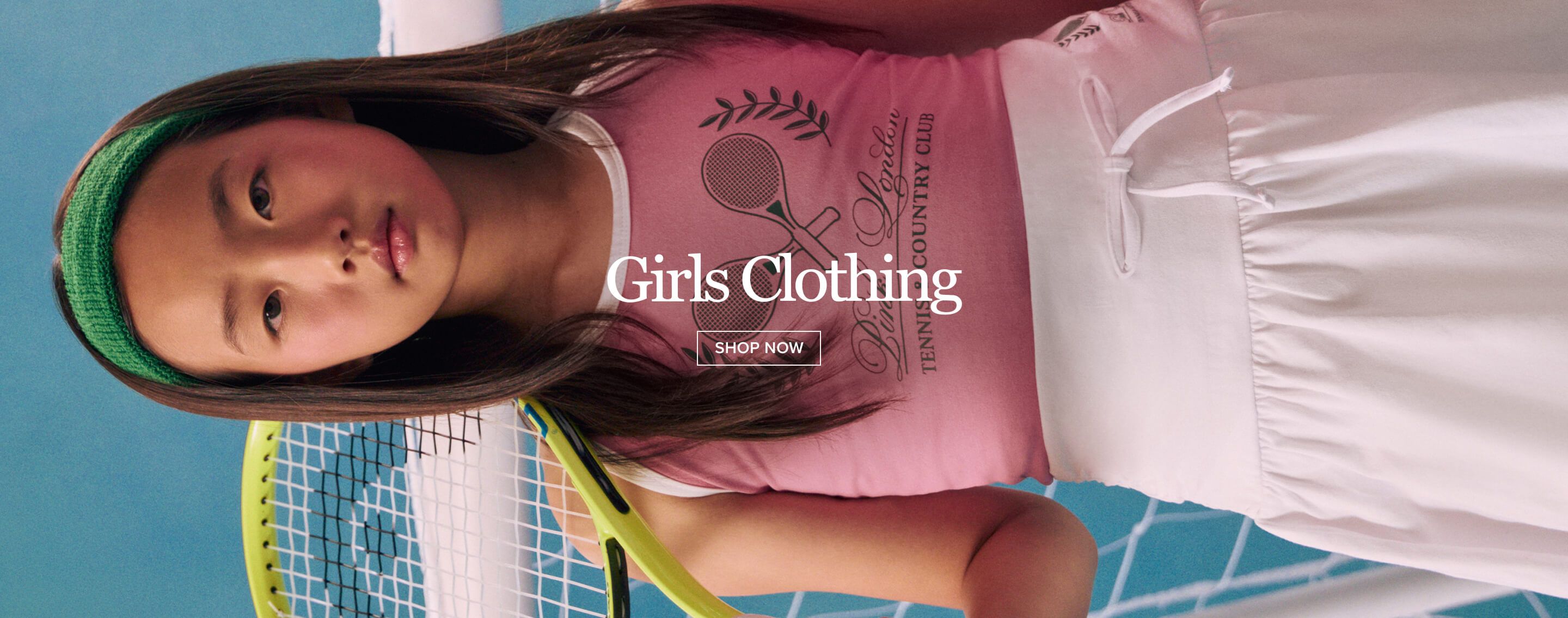 Two girls in vibrant pink and green activewear, one with a soccer ball, against a net background. "Girls Clothing" and "SHOP NOW" featured, promoting new kids' fashion.