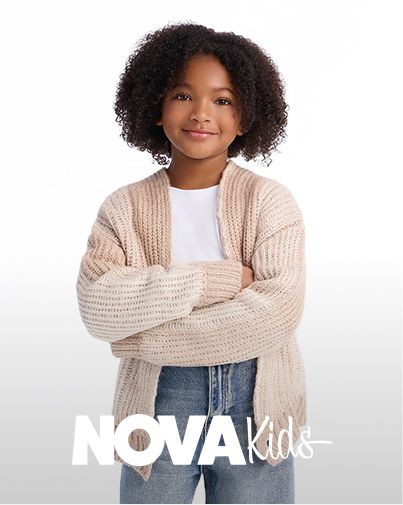 Smiling child wearing a beige NOVA Kids chunky knit cardigan over a white tee and jeans, showcasing cozy autumn fashion trends.