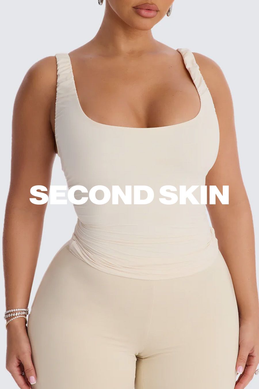 Woman in a seamless, light beige "Second Skin" top and pants. Promotes comfortable, figure-hugging loungewear and shapewear.