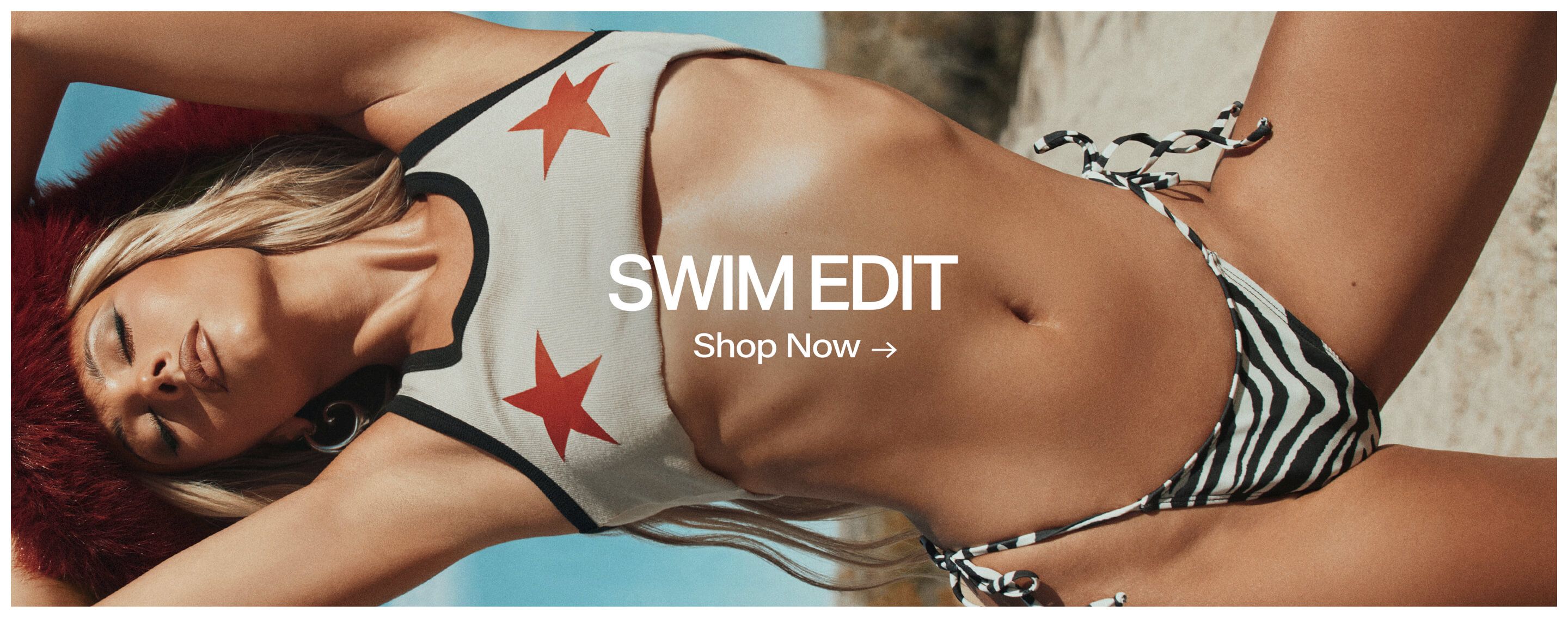 Blonde model in a cream star crop top and zebra bikini in a sunny desert, promoting the new Swim Edit. Shop summer swimwear now!
