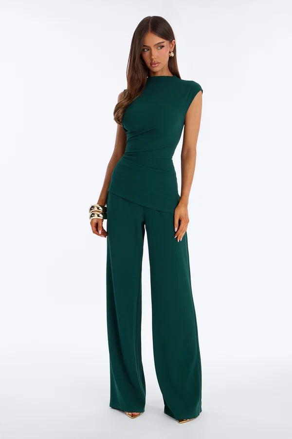 Elegant model in a chic emerald green matching set with a sleeveless draped top and wide-leg pants, showcasing new formal evening wear.
