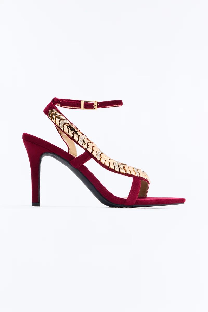 Burgundy velvet high heel sandals with a gold rhinestone chain strap and ankle buckle.