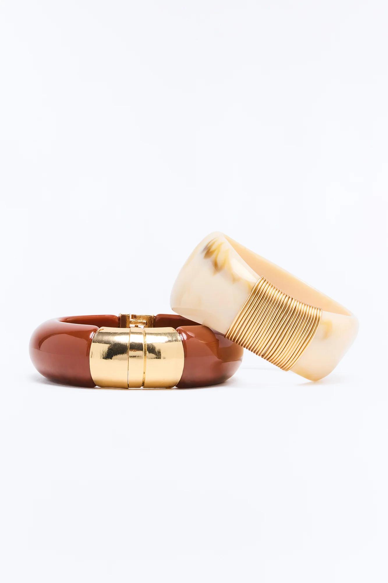 Stacked brown and marbled beige resin bracelets with bold gold accents, showcasing stylish fashion jewelry. Discover our new collection.