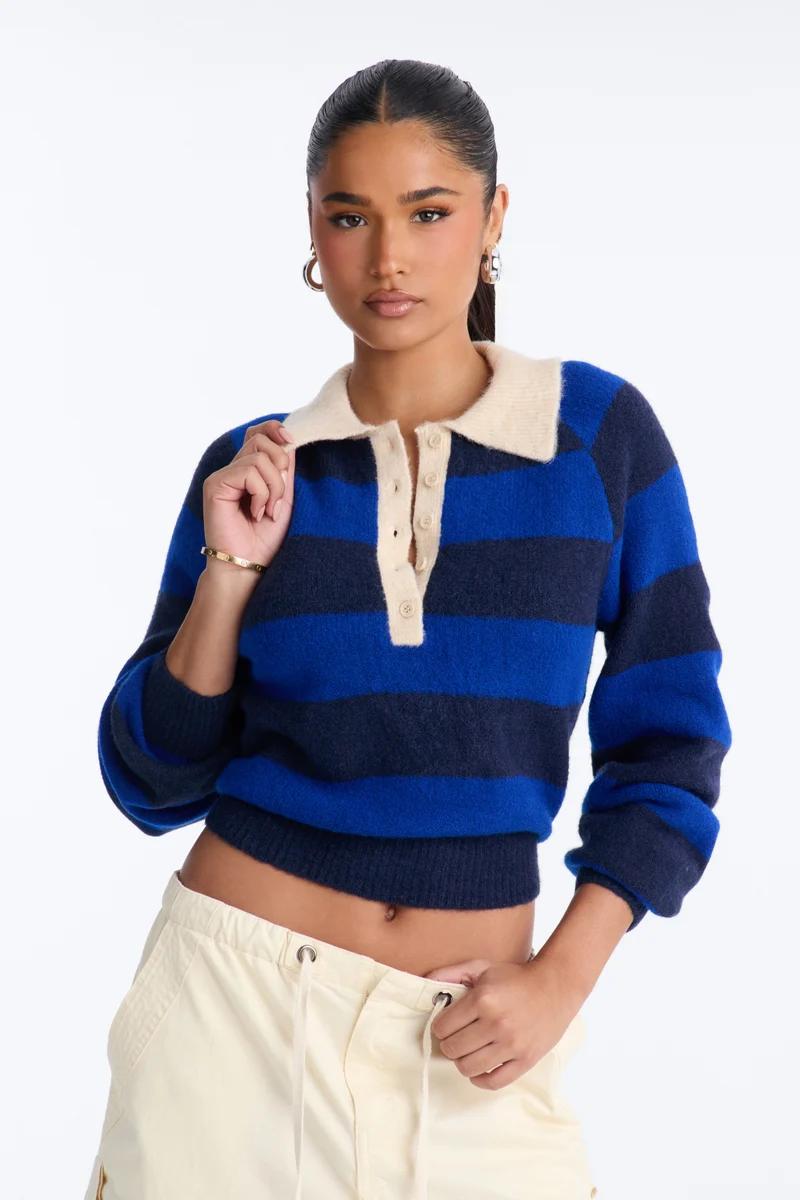 Woman wearing a blue and navy striped knit polo sweater with a cream collar.