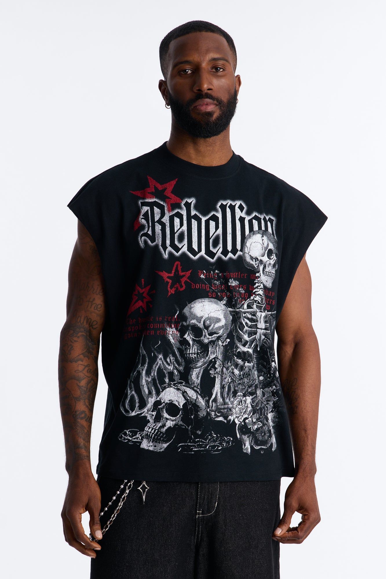 Man models a black sleeveless "Rebellion" graphic tee with striking red stars and skull designs, showcasing modern streetwear fashion.