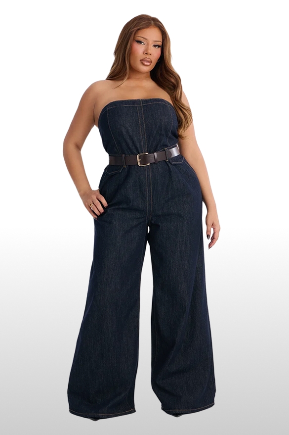 Plus size model wearing a strapless dark blue denim jumpsuit with wide legs and a brown belt, showcasing trendy women's fashion.