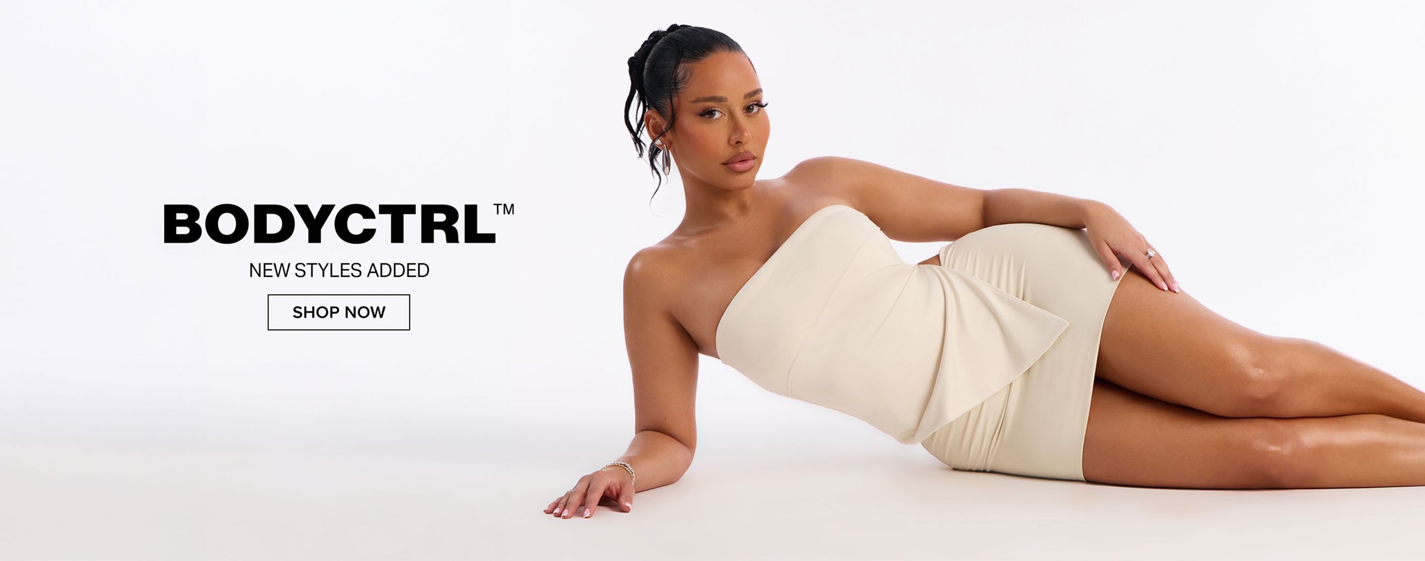 Woman in a cream strapless mini dress, posing on a white background. Promoting BODYCTRL new styles with a "SHOP NOW" call to action.