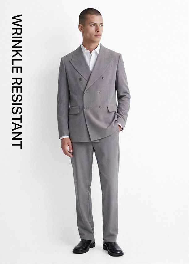 Hombre modela un elegante traje gris claro cruzado antiarrugas, ideal para un atuendo profesional nítido y sin esfuerzo.