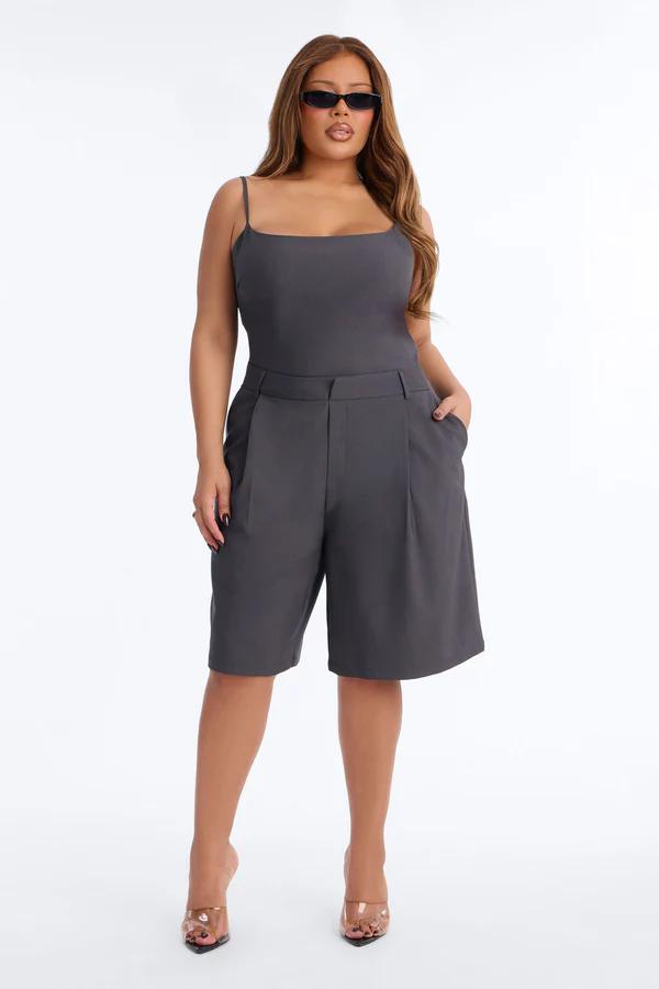 Stylish woman in charcoal grey square-neck bodysuit and wide-leg shorts, showcasing trendy plus size fashion from our new collection.