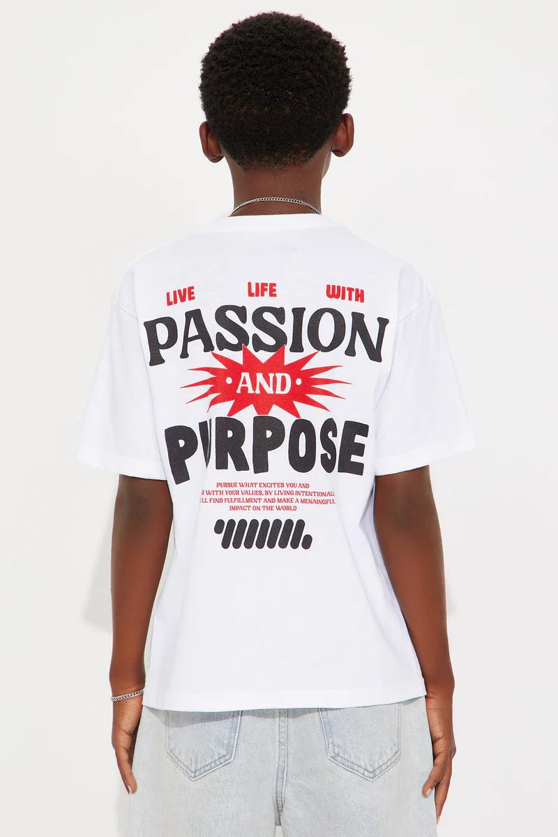 Young boy models a white "Passion and Purpose" graphic tee, light denim shorts, and white sneakers. Stylish kids' casual outfit.