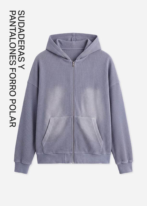Sudadera morada lavada con cremallera y textura gofrada, promocionando la acogedora colección de sudaderas y pantalones de forro polar.