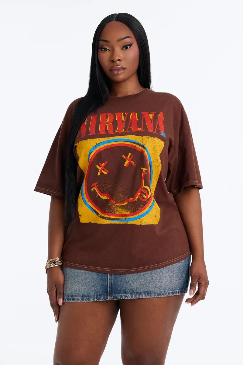 Black woman wearing an oversized brown Nirvana band graphic t-shirt and denim miniskirt.