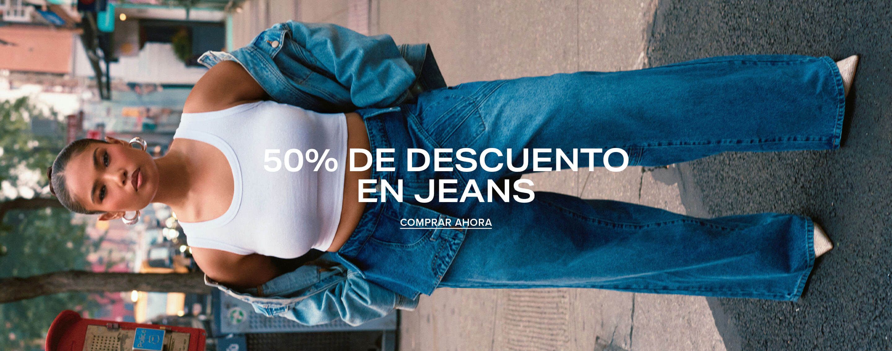 Mujer en vaqueros anchos de mezclilla y top blanco en una calle urbana, promocionando una venta de moda con un 50% de descuento en jeans.