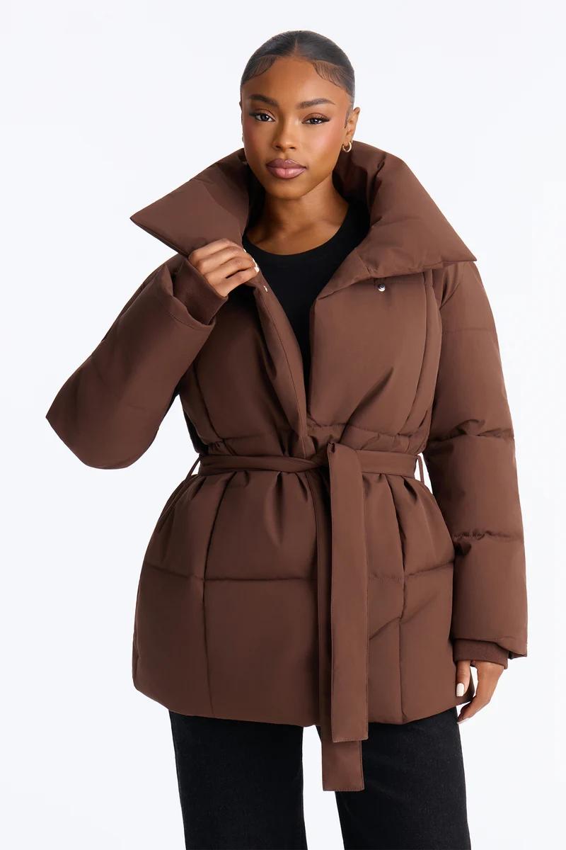 Woman wearing a stylish chocolate brown belted puffer jacket with a high collar.
