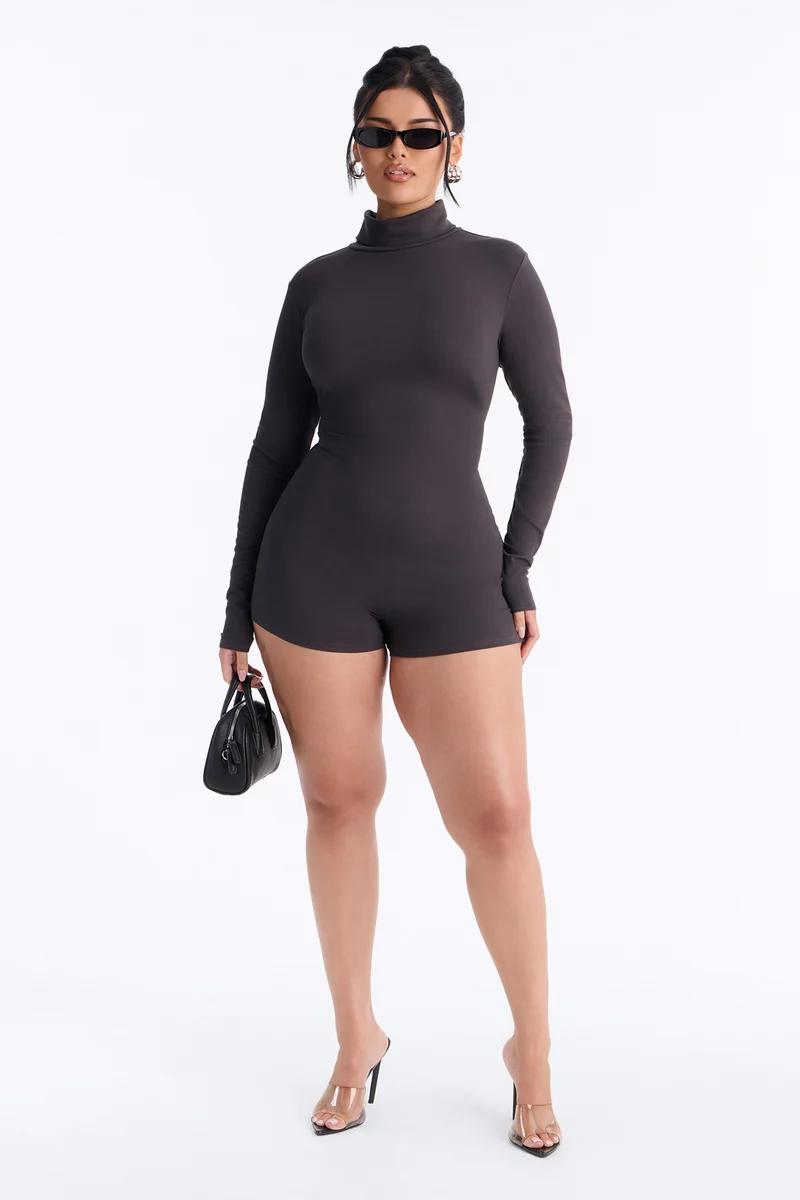 Confident woman modeling a new charcoal grey plus size spaghetti strap jumpsuit with flare legs, highlighting comfortable women's fashion.