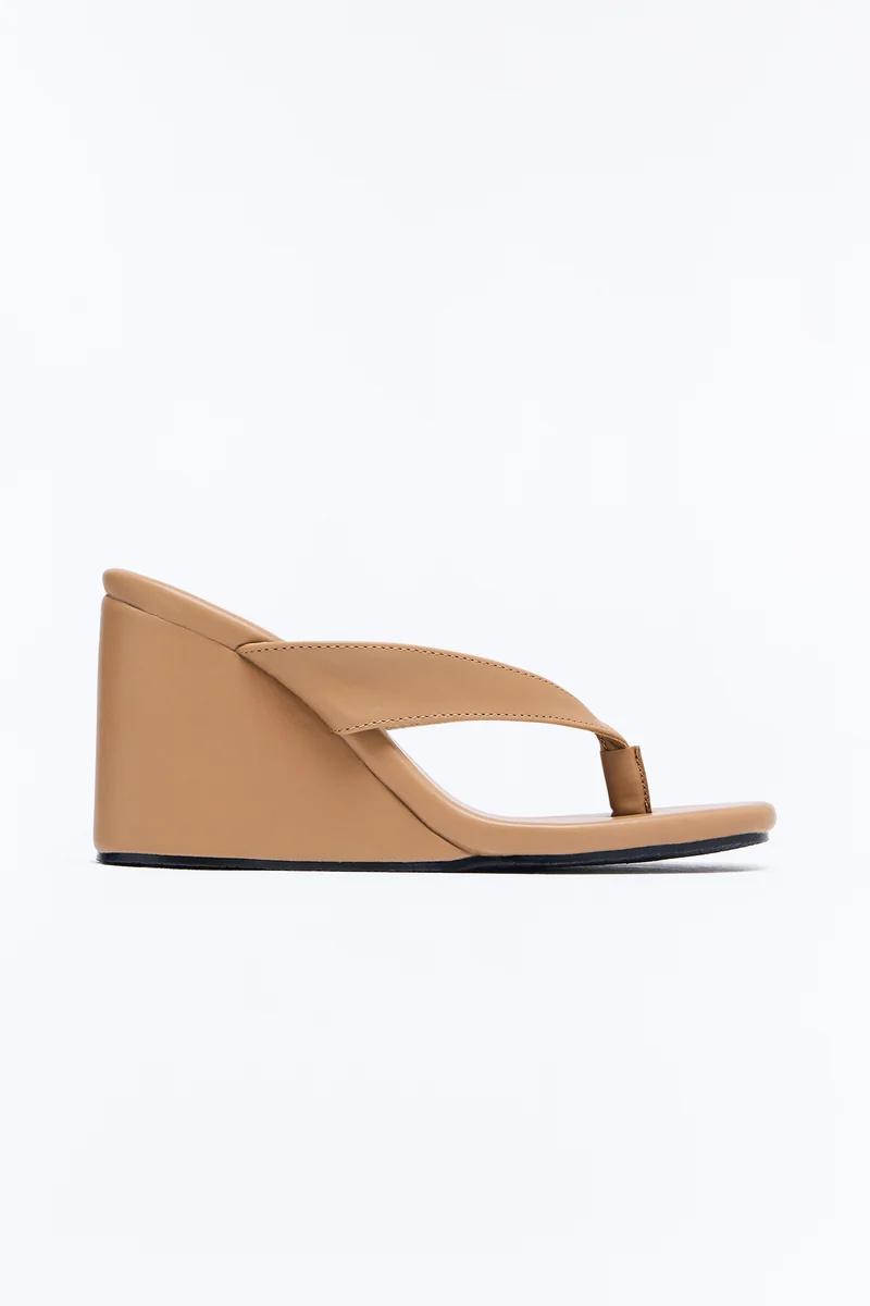 Tan leather wedge thong sandals with a minimalist design.