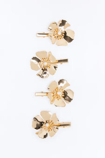 Four elegant gold floral hair clips for women, each with a pearl center, arranged vertically on a clean white background.