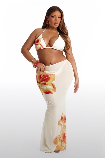 Plus-size model showcasing a white floral print bikini top and matching resort wear sarong skirt. Perfect for stylish beach outfits.