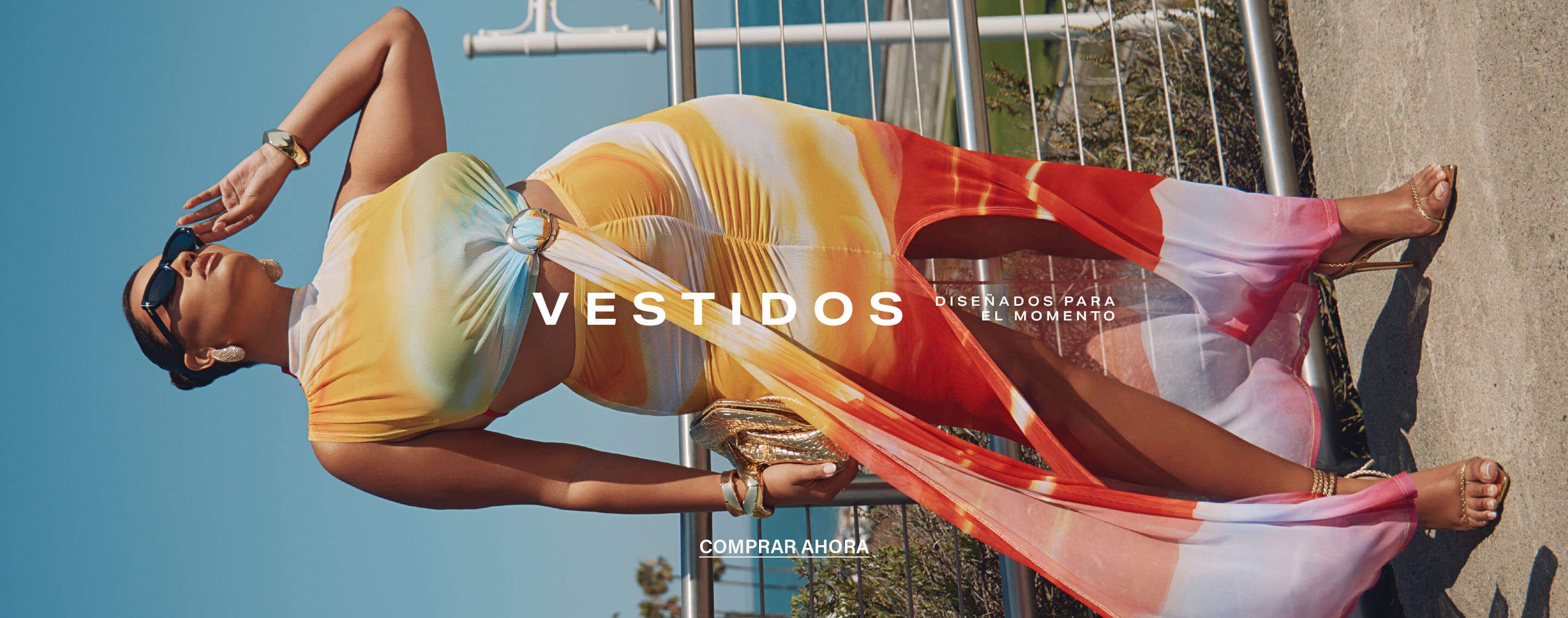 Modelo segura en vestido midi vibrante tie-dye con cut-out y abertura, accesorios para un look veraniego. ¡Compra la Dress Edit!
