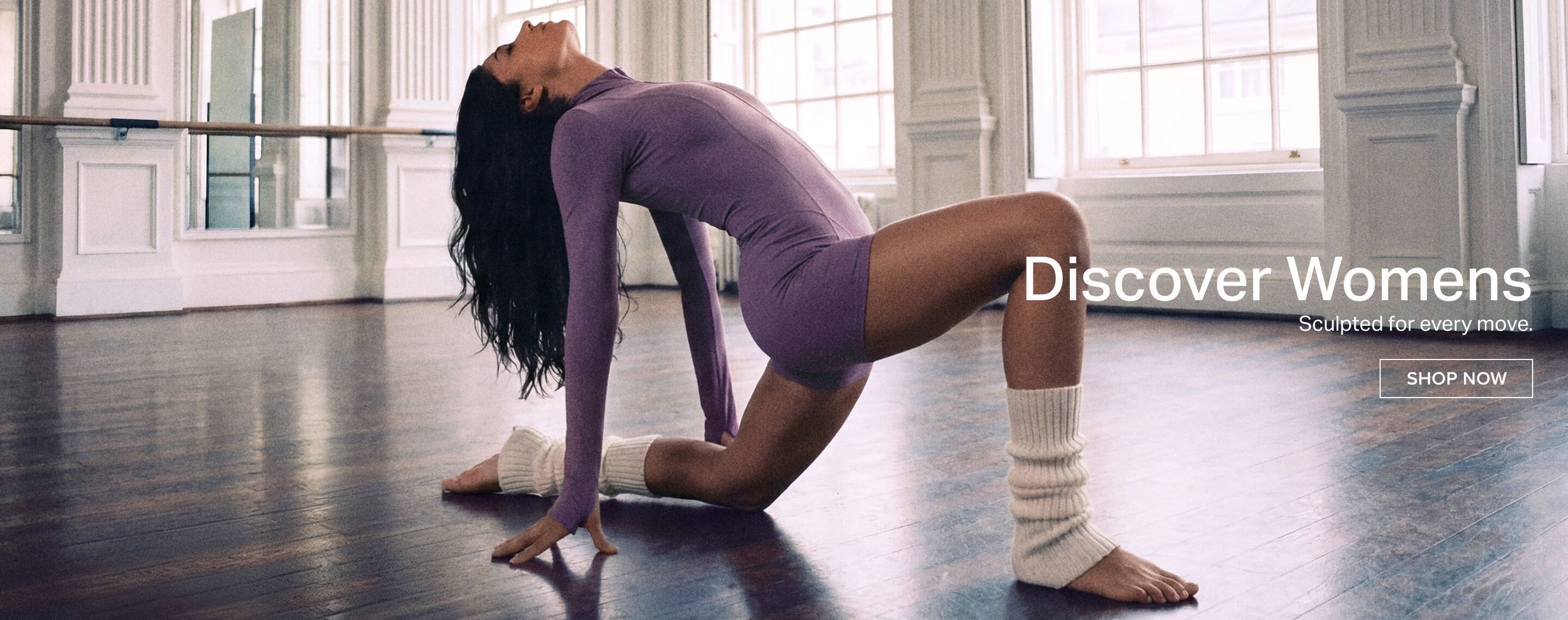 Woman in purple unitard stretching in a bright studio, promoting new womens sculpted activewear for optimal movement. Shop now.