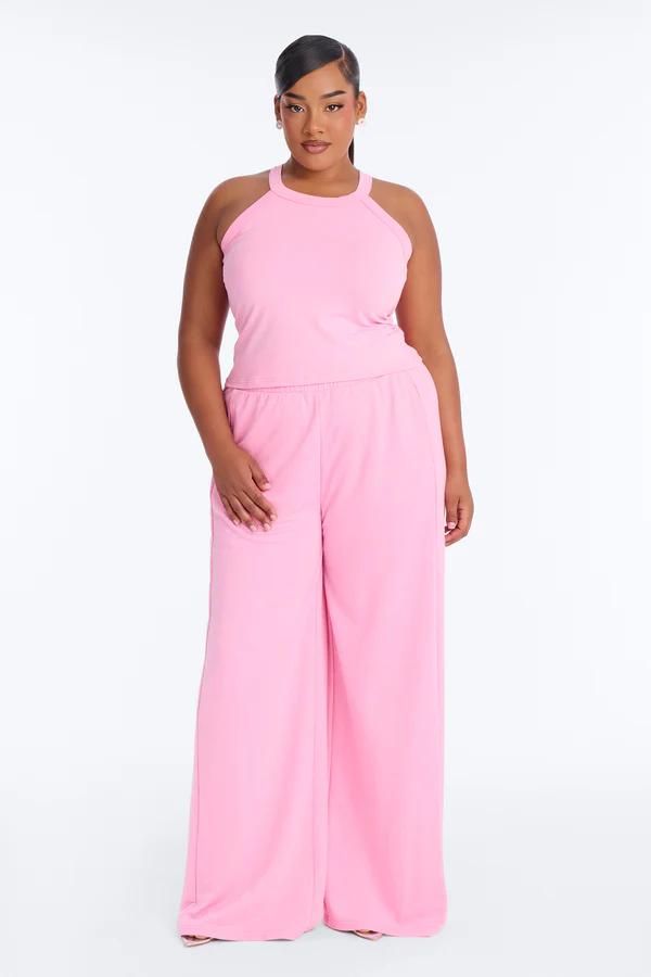 Model in a vibrant pink plus size loungewear set: a halter top and wide-leg pants. Perfect comfortable fashion for spring.